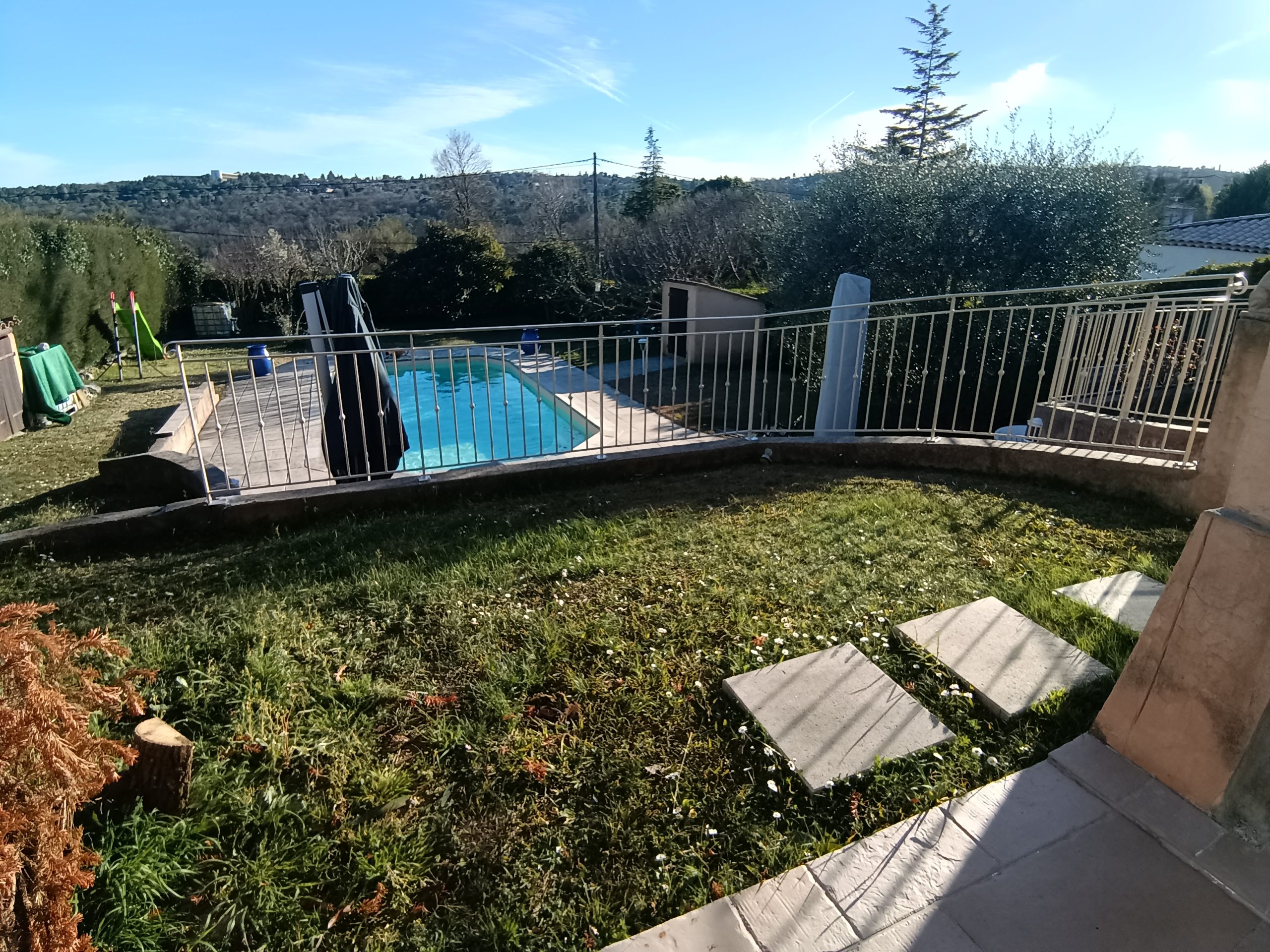 Garde-corps sur une terrasse avec vue sur le jardin et la piscine